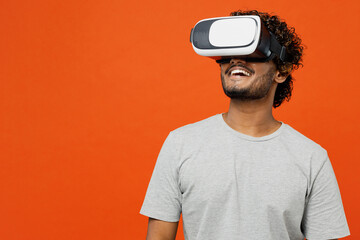 Young smiling amazed cool fun happy Indian man he wears t-shirt casual clothes watching in vr...