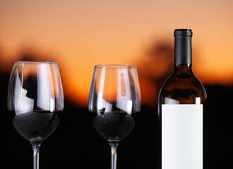 wine bottle and glass at sunset