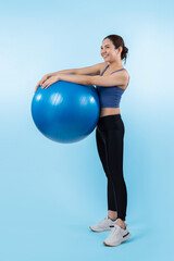Fototapeta na wymiar Young attractive asian woman portrait in sportswear with fit ball targeting on abs muscle for effective energetic daily workout routine. Studio shot and isolated background. Vigorous