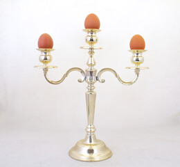 Three eggs on a candelabra isolated against a clear background with copy space