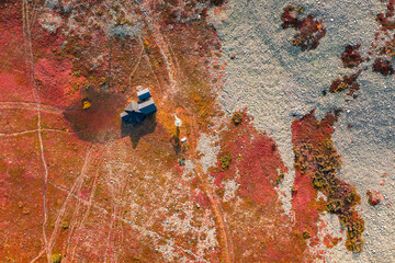 Aerial view of a cabin, fall colored trees and vivid red and orange nature in Levi fell, Kittilä,...