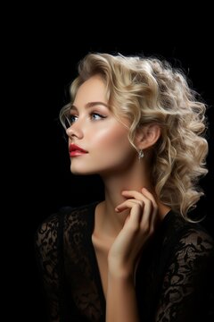 Side shot of a beautiful Caucasian woman with blond hair dressed in black looking to an isolated side on a black background copy-space