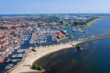 Drone photo of the former Zuiderzee island of Urk with beach harbors and old houses on a beautiful sunny day with cloudless sky