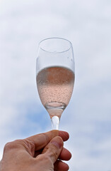 Glass of rosé wine against cloudy sky