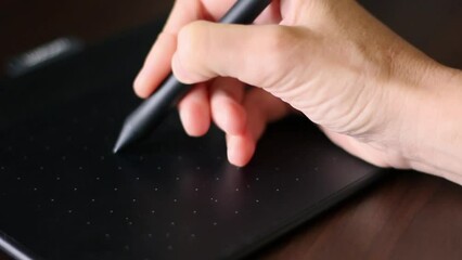 A hand draws with a stylus on a graphics tablet. Graphic designer and artist. creative work, inspiration and art. Electronic art equipment. Closeup video motion footaget