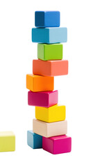 Fototapeta premium Colorful blocks stacked high in a tower, ready to topple isolated