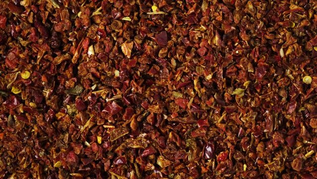 Dried crushed red pepper Gochugaru, close-up. 4K video, counterclockwise rotating. Medium-ground red dry pepper for kimchi, gochujang and other savory dishes. Popular spicy condiments.