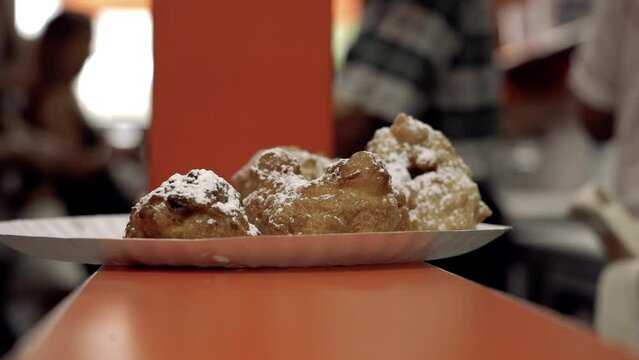 Close up Zeppole with powdered sugar people in background Williamsburg Brooklyn