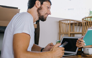 Female assistant showing opened notebook to bearded colleague