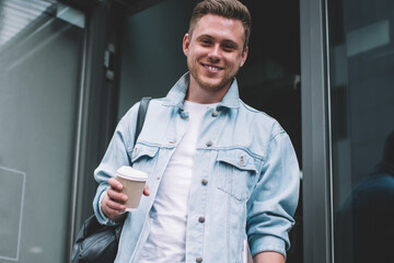 Smiling man with coffee cup on street