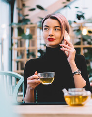 Trendy content modern woman talking on phone at cafe