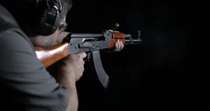 Shooting Kalashnikov weapon at highs-speed 800 fps slow-motion. Person aiming and firing AK-47 Rifle. Gun speed-ramp