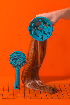 Crop anonymous person holding hair dryer with extensions near hair brush