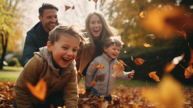 Happy family playing with leaves in autumn park.