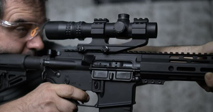 Shooting a single shot with an assault rifle detail close-up of finger pulling trigger in super slow-motion 800 fps