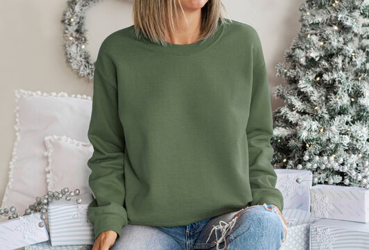 Girl wear empty green sweatshirt with copy space for your text or design. Military green Hoodie mock up with Christmas holiday green-white accessoriess , xmas tree decor