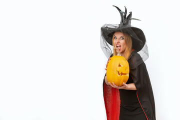Funny young woman with jack-o'-lantern in witch's hat . White background, space for text. Black clothes. Halloween Party.