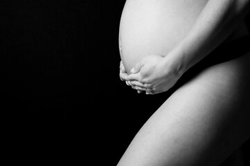 Barriga embarazada con manos en la oscuridad