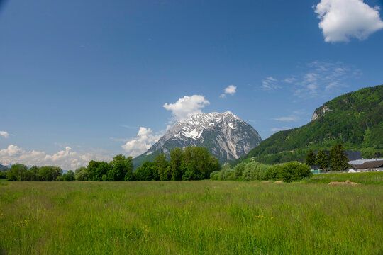 Summer austrian landscape with green meadows and Grimming mountain (2.351 m), an isolated peak in the Dachstein Mountains, in Styria region, Austria