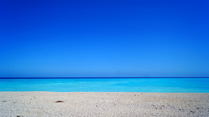Fototapeta premium Sunny and calm day in Caribbean Sea, Dominican Republic. Close up of white sand, turquoise gradient colors and sea without waves.