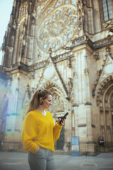 woman in Prague having walking tour, using phone and walking