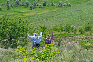 Two women are on green rural landscape background.