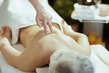Closeup on medical massage therapist massaging clients back