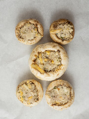 Breadcrumbs, herb and cheese stuffed mushrooms cup on grey color cooking paper. High quality...