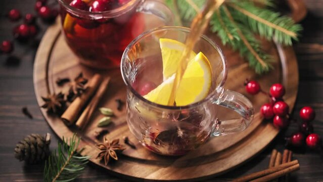 Hot mulled wine with oranges, cranberries and spices in a glass. A traditional warming drink for the autumn-winter season. Stock video 4k