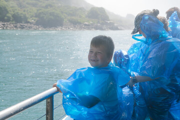 Kid boy observing niagara falls on sheap. Panoramic aerial view of American  side view of Niagara...
