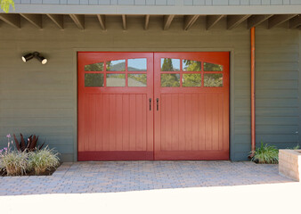 Taupe colored cottage with an old fashioned single car garage 