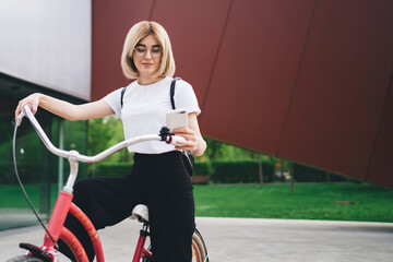 Lady resting on bicycle and texting in social media