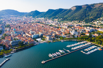 Picturesque view of city of Como on shore of Lake Como on background of mountain at sunny morning, Italy