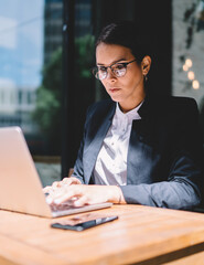 Female entrepreneur using laptop in street cafe