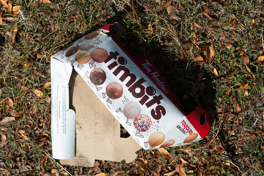 discarded cardboard box that once contained Timbits, bite-sized doughnut holes on the ground