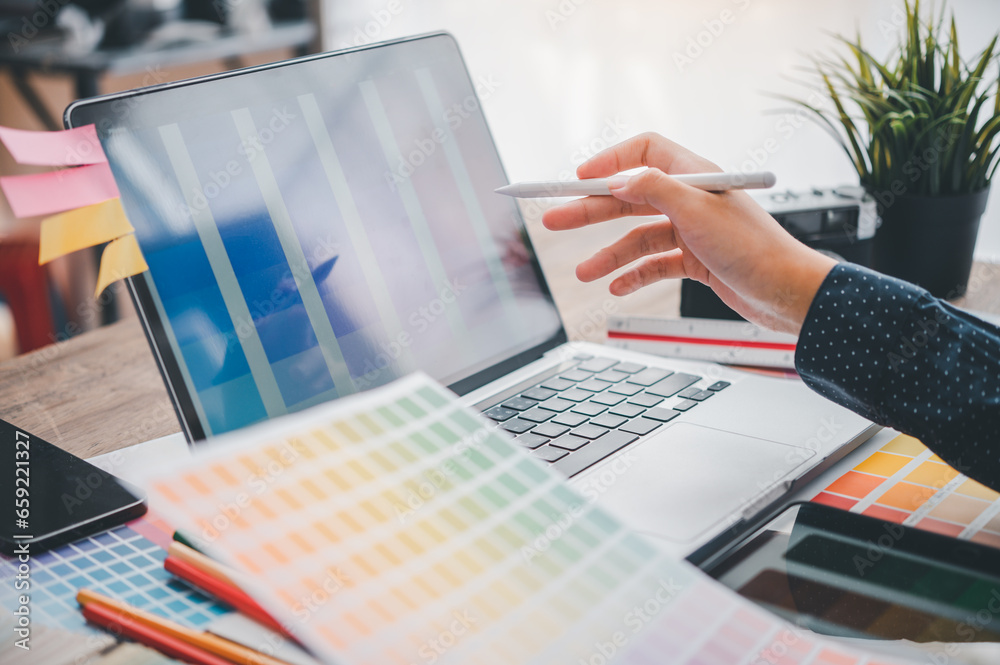 Fototapete Graphic designer architects who work with laptops and color comparison tables for design work..