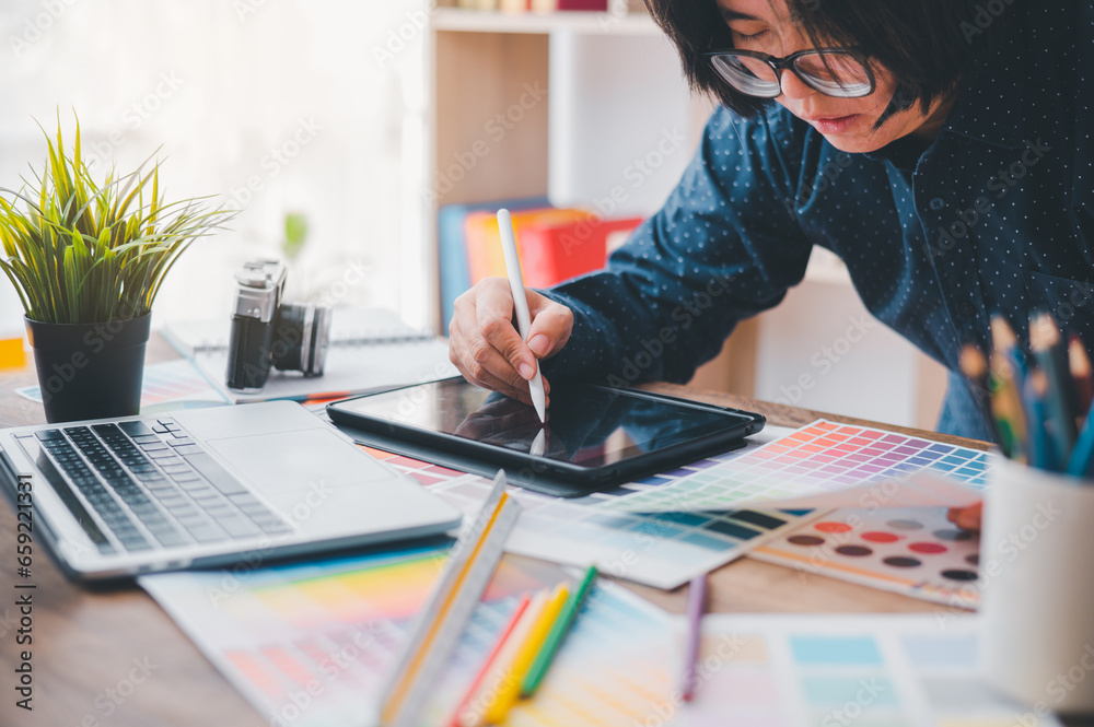 Fototapete Graphic designer architects who work with laptops and color comparison tables for design work..