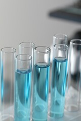 Test tubes with light blue liquid in laboratory, closeup