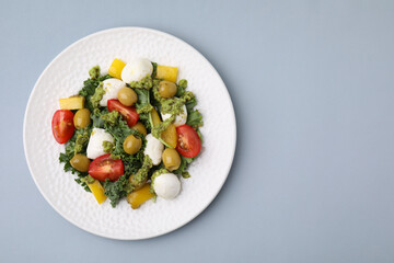 Delicious salad with pesto sauce on light grey table, top view. Space for text