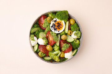 Delicious salad with pesto sauce in bowl on beige table, top view