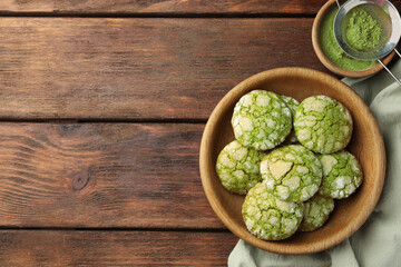Bowl with tasty matcha cookies and powder on wooden table, flat lay. Space for text