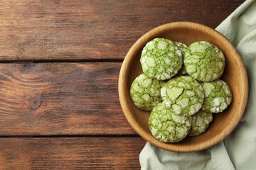 Bowl with tasty matcha cookies on wooden table, top view. Space for text