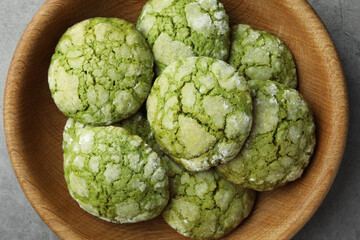 Bowl with tasty matcha cookies on grey textured table, top view