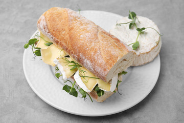 Tasty sandwich with brie cheese on light grey table, closeup