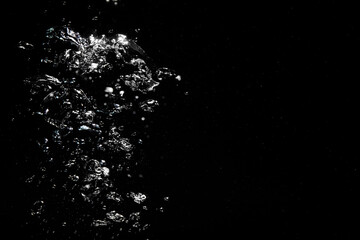 Many air bubbles in water on black background, space for text