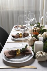 Beautiful autumn table setting. Plates, cutlery, glasses and floral decor indoors