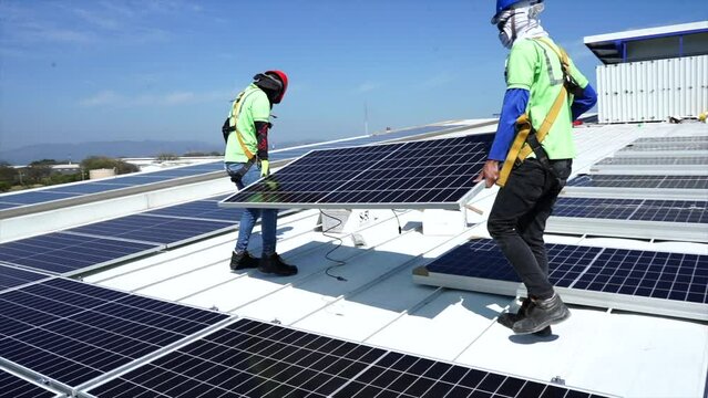 View of the installation of solar panels on a warehouse roof -green energy - renewable energy