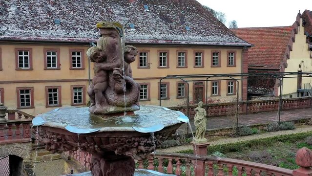 Drone flight, drone shot around the fountain in the castle garden of Bronnbach Monastery, winter, light snow, Wertheim, Baden-Wuerttemberg, Germany, Europe
