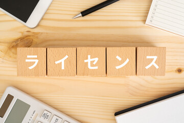 ライセンスと書かれたブロック、スマホ、電卓、ノート