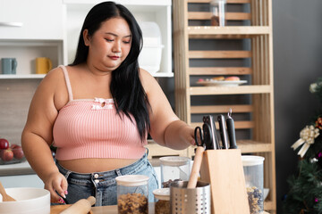 Happy Asia plus size woman prepare cooking bread in kitchen at home